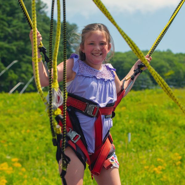 girl harnessed into bungee jump ride