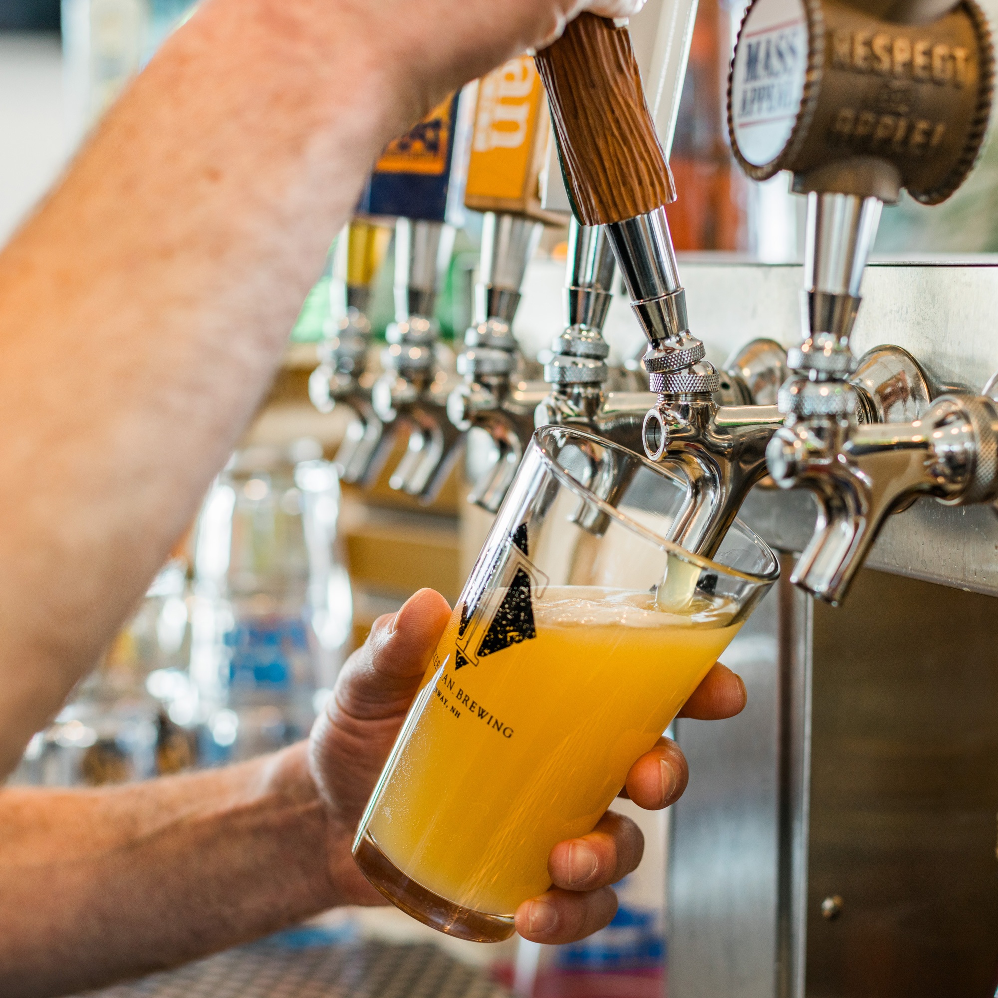 Pouring beer from tap into Tuckerman Brewing glass